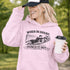 Woman wearing grey hoodie with “When In Doubt Punch It Out” soccer goalie design featuring diving goalkeeper making a save