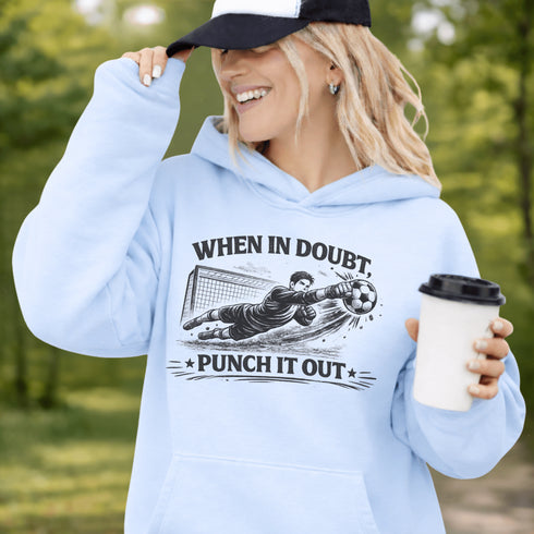 Woman wearing grey hoodie with “When In Doubt Punch It Out” soccer goalie design featuring diving goalkeeper making a save