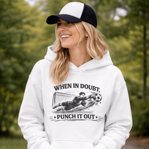 Woman wearing grey hoodie with “When In Doubt Punch It Out” soccer goalie design featuring diving goalkeeper making a save