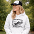 Woman wearing grey hoodie with “When In Doubt Punch It Out” soccer goalie design featuring diving goalkeeper making a save