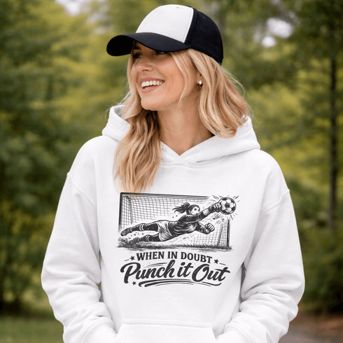 woman wearing hoodie with “When In Doubt Punch It Out” soccer goalie design featuring diving goalkeeper making a save in front of net