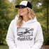 woman wearing hoodie with “When In Doubt Punch It Out” soccer goalie design featuring diving goalkeeper making a save in front of net