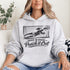 woman wearing hoodie with “When In Doubt Punch It Out” soccer goalie design featuring diving goalkeeper making a save in front of net
