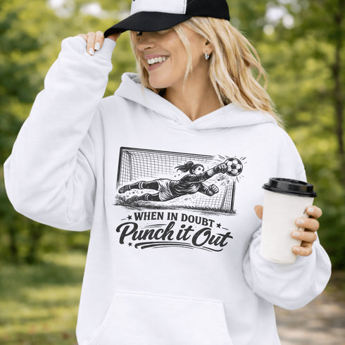 woman wearing hoodie with “When In Doubt Punch It Out” soccer goalie design featuring diving goalkeeper making a save in front of net