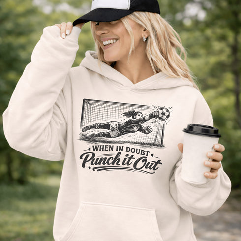 woman wearing hoodie with “When In Doubt Punch It Out” soccer goalie design featuring diving goalkeeper making a save in front of net