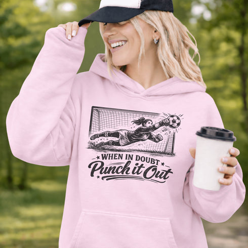 woman wearing hoodie with “When In Doubt Punch It Out” soccer goalie design featuring diving goalkeeper making a save in front of net