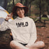 Step into the wild with our unique camping hoodie, featuring a captivating camping scene intricately etched inside the words "Into The Wild". Crafted for outdoor enthusiasts, this hoodie is not just a piece of clothing but a symbol of adventure and exploration.