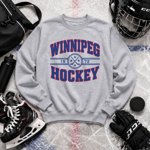 Winnipeg Hockey 1972 vintage-style unisex crewneck sweatshirt with collegiate lettering, crossed hockey sticks and retro hockey graphic by Prairie Life Co.