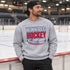 Winnipeg Hockey unisex crewneck sweatshirt featuring vintage navy and red collegiate lettering with a hockey puck graphic, designed by Prairie Life Co.