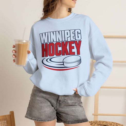 Winnipeg Hockey unisex crewneck sweatshirt featuring vintage navy and red collegiate lettering with a hockey puck graphic, designed by Prairie Life Co.