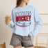 Winnipeg Hockey unisex crewneck sweatshirt featuring vintage navy and red collegiate lettering with a hockey puck graphic, designed by Prairie Life Co.
