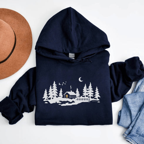 Wrap yourself in winter wonder with our Snowy Cabin Hoodie — a cozy escape you can wear.