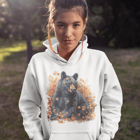 Featuring a detailed graphic of a black bear nestled comfortably among a colorful bed of autumn leaves, this hoodie brings warmth and woodland charm to your wardrobe.