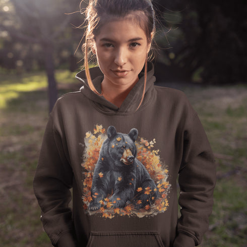 Featuring a detailed graphic of a black bear nestled comfortably among a colorful bed of autumn leaves, this hoodie brings warmth and woodland charm to your wardrobe.