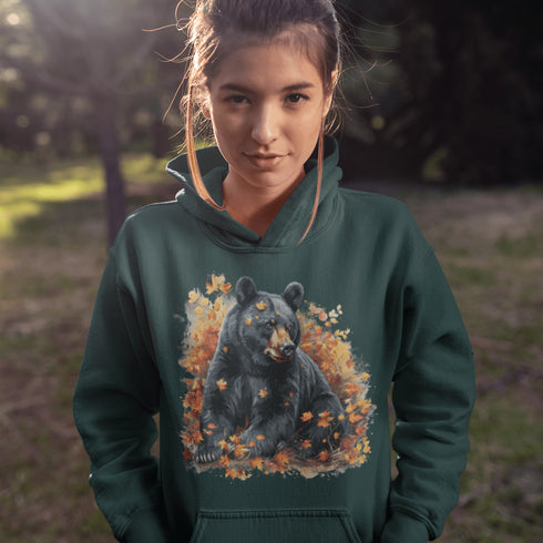 Featuring a detailed graphic of a black bear nestled comfortably among a colorful bed of autumn leaves, this hoodie brings warmth and woodland charm to your wardrobe.