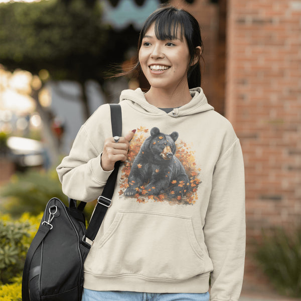 Featuring a detailed graphic of a black bear nestled comfortably among a colorful bed of autumn leaves, this hoodie brings warmth and woodland charm to your wardrobe.