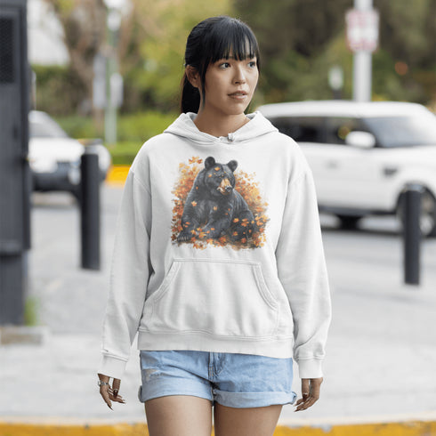 Featuring a detailed graphic of a black bear nestled comfortably among a colorful bed of autumn leaves, this hoodie brings warmth and woodland charm to your wardrobe.
