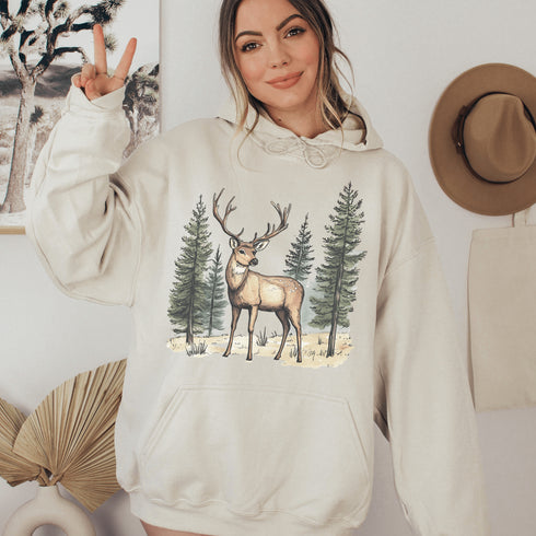 This hoodie features a beautifully crafted design of a majestic deer standing amidst the forest, capturing the quiet elegance of the woods.