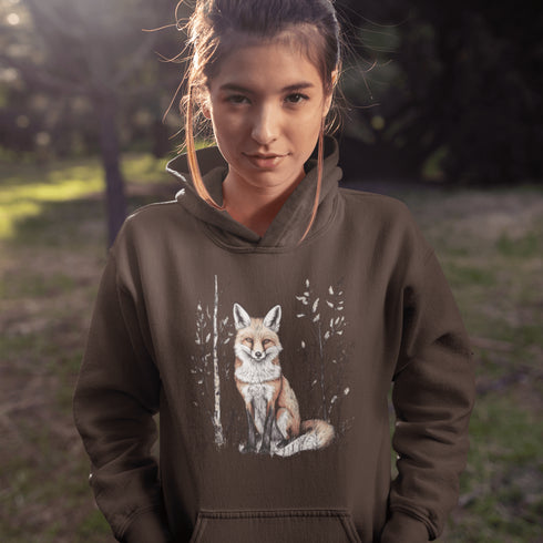 This hoodie features a stunning graphic of a vibrant red fox poised amidst the shadows and light of a lush woodland scene.