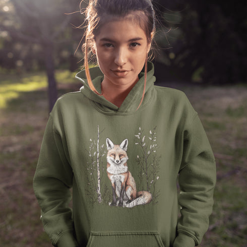 This hoodie features a stunning graphic of a vibrant red fox poised amidst the shadows and light of a lush woodland scene.