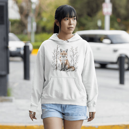 This hoodie features a stunning graphic of a vibrant red fox poised amidst the shadows and light of a lush woodland scene.