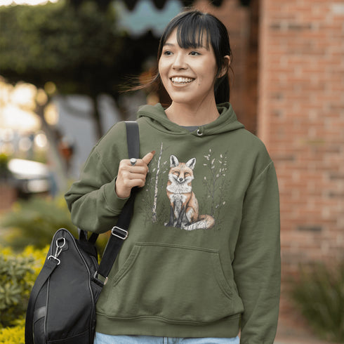 This hoodie features a stunning graphic of a vibrant red fox poised amidst the shadows and light of a lush woodland scene.