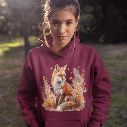 This hoodie features a striking image of a red fox standing alert and proud in its natural habitat, surrounded by lush foliage and the earthy colors of the wilderness.