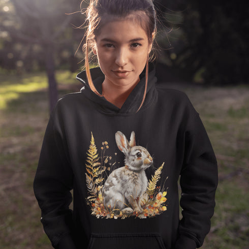 This cozy hoodie features a playful rabbit nestled among vibrant fall foliage, surrounded by the warm oranges, reds, and yellows of the season.