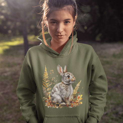 This cozy hoodie features a playful rabbit nestled among vibrant fall foliage, surrounded by the warm oranges, reds, and yellows of the season.