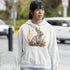 This cozy hoodie features a playful rabbit nestled among vibrant fall foliage, surrounded by the warm oranges, reds, and yellows of the season.