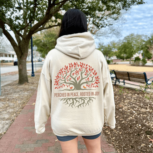 This design features a beautifully crafted tree with flowing roots, symbolizing strength and connection, paired with the uplifting saying, "Perched in peace, rooted in joy."