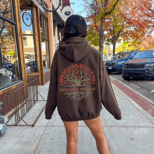 This design features a beautifully crafted tree with flowing roots, symbolizing strength and connection, paired with the uplifting saying, "Perched in peace, rooted in joy."