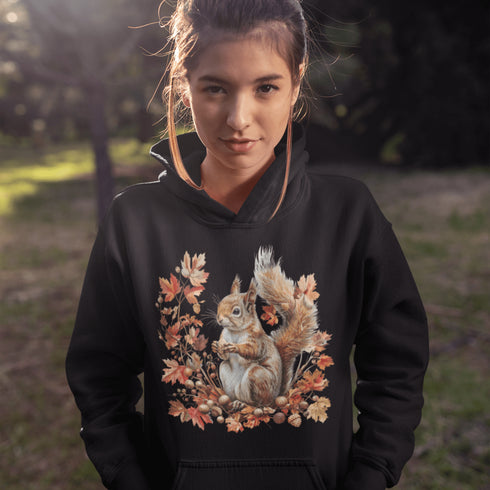 Get ready for fall with the Acorn Gatherer Hoodie, featuring an adorable squirrel surrounded by autumn foliage and a stash of acorns.