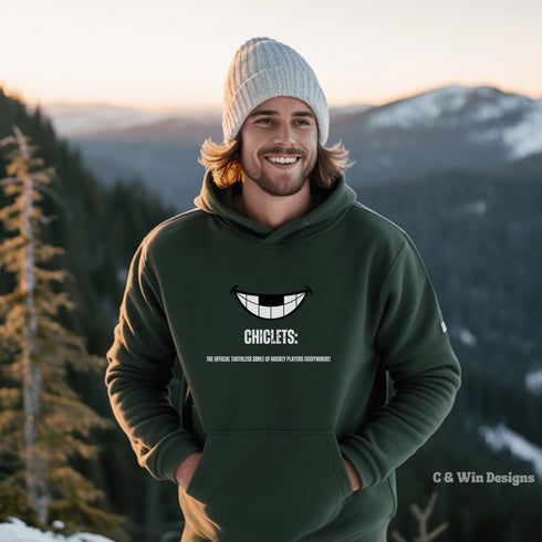 Our gender-neutral Chiclets hoodie is the ultimate statement piece for any hockey lover. Featuring a smiling mouth with missing front teeth, this hoodie perfectly captures the rugged and tough spirit of hockey players.