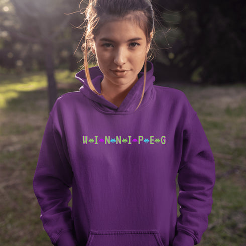 This picture showcases the Winnipeg Retro Gaming Hoodie that has a bold green gaming font with space creatures separating the Winnipeg Letters