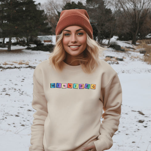 Introducing our newest addition to your wardrobe - the trendy graphic sweatshirt featuring colorful Winnipeg Scrabble Titles.