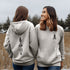 This hoodie features a unique design that showcases the beauty of Manitoba's nature icons, including prairie wheat, geese, bison, trees, and a big sun.