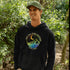 This hoodie features a colorful mountain graphic on the front and the inspiring saying "Not All Who Wander Are Lost" printed on the front.