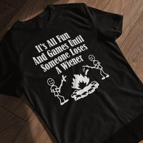Our Camping tee features two adorable stick figure people roasting wieners over a cozy campfire. And with the hilarious slogan "It's All Fun & Games Until Someone Loses A Wiener," you'll be the life of the party at any camping trip!