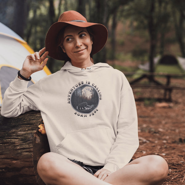 This gender neutral hoodie features a stunning design of a grizzly bear roaming on a campsite with the moon shining behind it. The saying "Adventure Is Calling Roam Free" is printed boldly, capturing the essence of the great outdoors and the spirit of camping.