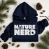 Navy hoodie with 'Nature Nerd' text on a white background with pinecones and branches.