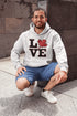 Love Canada hoodie featuring bold black lettering and red Canadian maple leaf graphic on a unisex sweatshirt