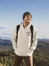Man wearing hiking hoodie with large nature graphic on back walking in the forest