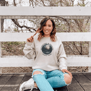 This gender neutral crewneck sweatshirt features a stunning design of a grizzly bear roaming on a campsite with the moon shining behind it. The saying "Adventure Is Calling Roam Free" is printed boldly, capturing the essence of the great outdoors and the spirit of camping. Perfect for any outdoor adventure