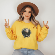 This gender neutral crewneck sweatshirt features a stunning design of a grizzly bear roaming on a campsite with the moon shining behind it. The saying "Adventure Is Calling Roam Free" is printed boldly, capturing the essence of the great outdoors and the spirit of camping. Perfect for any outdoor adventure