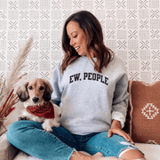 Introducing a sweatshirt that will make all the introverts and homebodies out there jump with joy! This gender-neutral sweatshirt is perfect for those who prefer to stay indoors and avoid the chaos of the outside world. With the witty slogan "Ew, People" printed on the front, you'll never have to explain your social preferences again. 