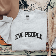 Introducing a sweatshirt that will make all the introverts and homebodies out there jump with joy! This gender-neutral sweatshirt is perfect for those who prefer to stay indoors and avoid the chaos of the outside world. With the witty slogan "Ew, People" printed on the front, you'll never have to explain your social preferences again. 