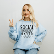 Introducing the ultimate fashion statement for introverts and homebodies everywhere: the Social Distancing Expert sweatshirt! Made with premium quality material, this sweatshirt is perfect for those who love to stay snuggled up at home and avoid social interaction at all costs. With its eye-catching design and hilarious slogan, this gender neutral sweatshirt is sure to turn heads and get laughs wherever you go. 