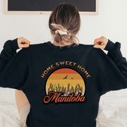 Introducing the perfect addition to your wardrobe for those chilly Canadian nights - our gender neutral Manitoba Home Sweet Home Sweatshirt! Designed with a stunning Prairie sunset on the back, complete with wheat and the phrase "Home Sweet Home Manitoba," this sweater is not only stylish but also serves as a nod to your love for the beautiful Canadian nature. 