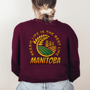 Introducing the perfect addition to your wardrobe: the Prairie Life Is The Best Life-Manitoba sweatshirt. This gender-neutral nature shirt features a stunning graphic of a farmer's field, complete with wheat stalks swaying in the breeze.